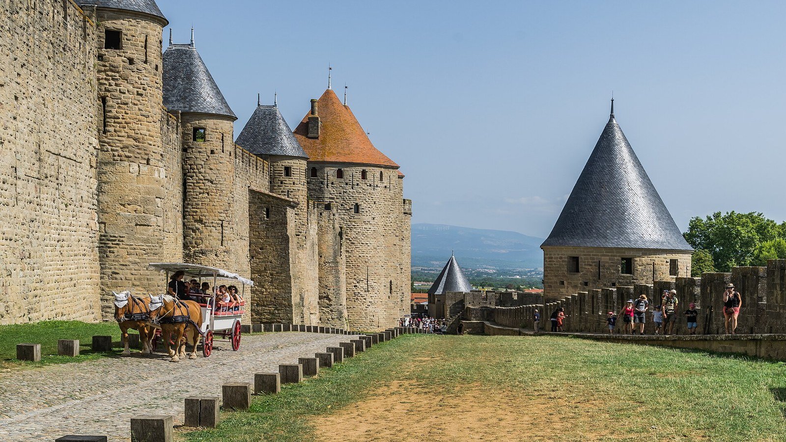 Walking on the ramparts of Carcassonne with the towers of Porte Narbonnaise