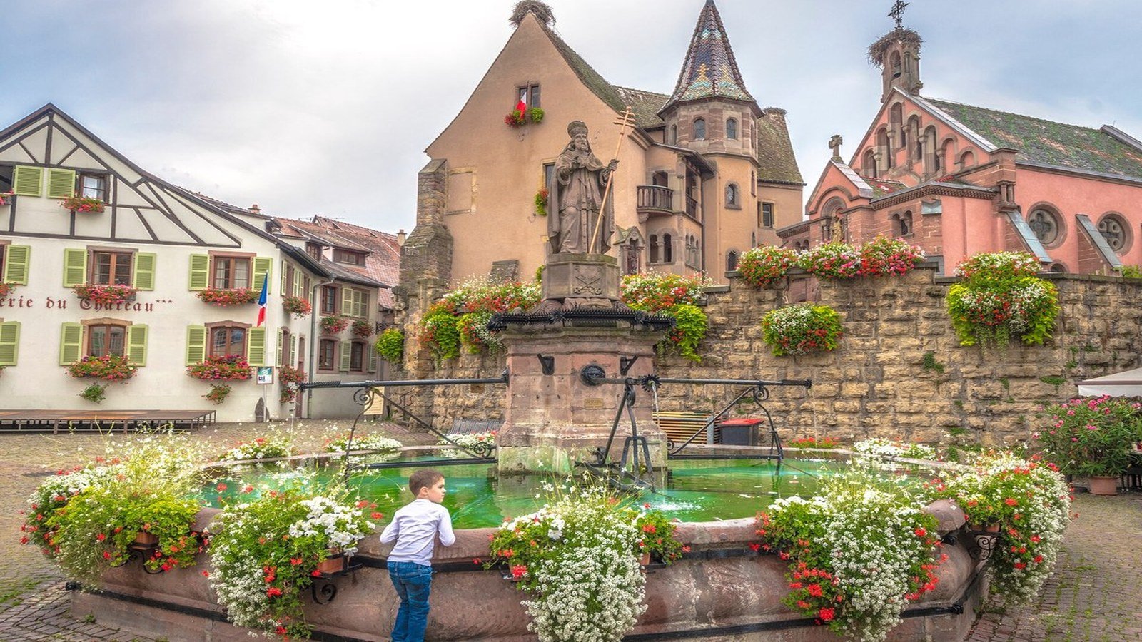 Colorful half-timbered houses with geraniums in the narrow streets of Eguisheim, Alsace