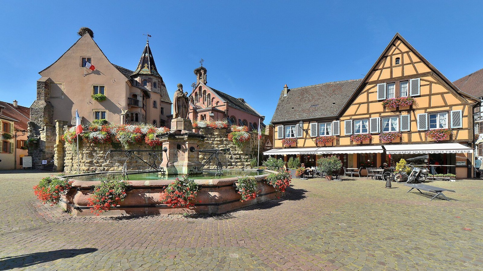 Eguisheim Christmas market with twinkling lights and wooden stalls in the central square at night