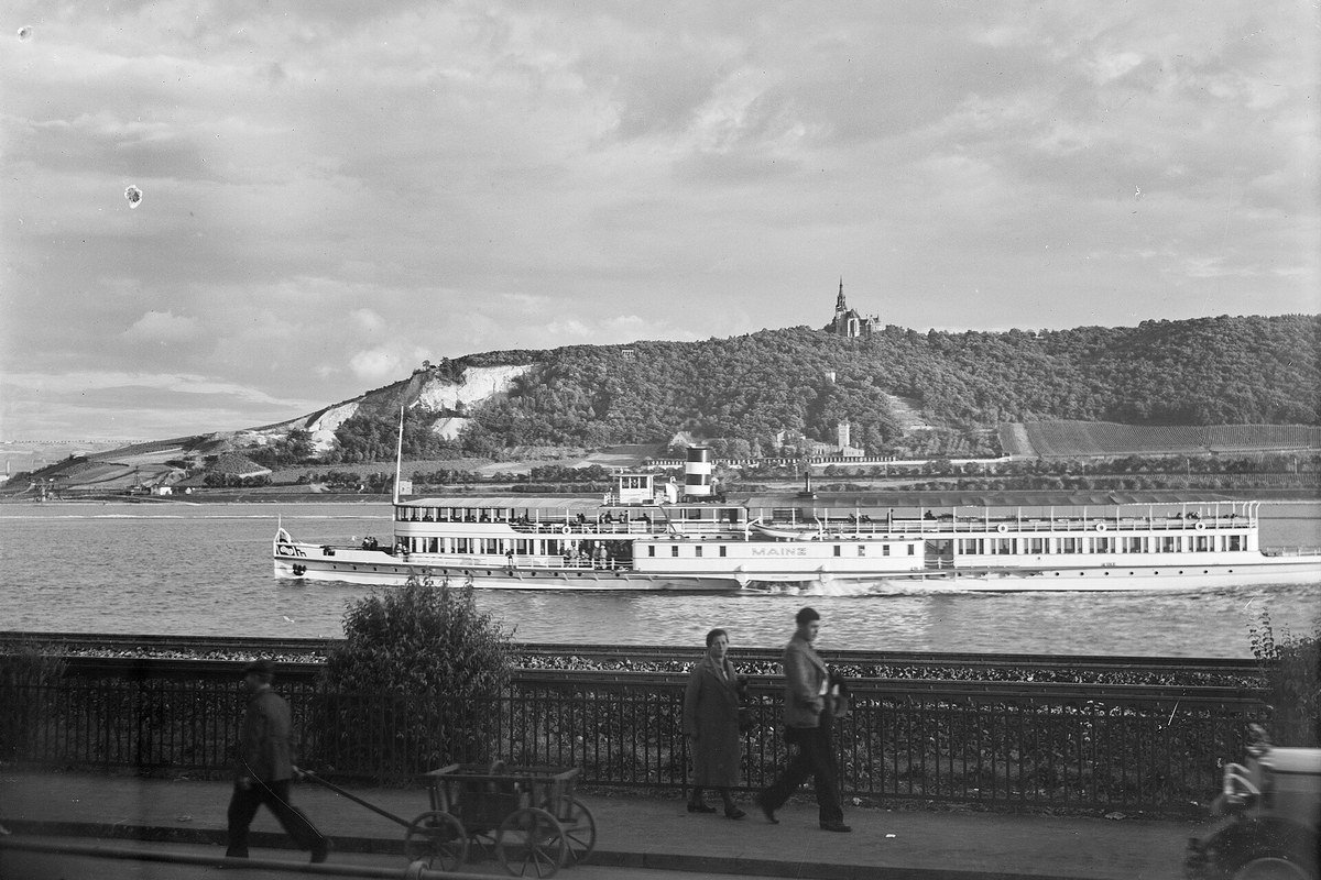 Rhine river promenade in Mainz with the Theodor Heuss bridge and the city skyline at sunset