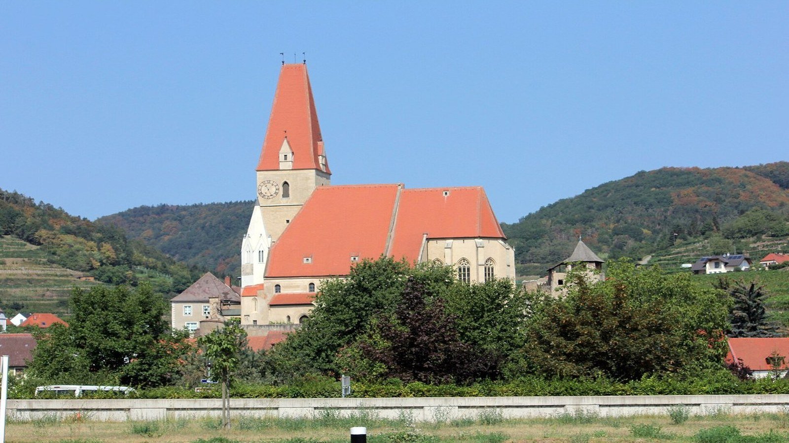 Fortified Gothic parish church Mariä Himmelfahrt in Weissenkirchen with defensive walls and white tower