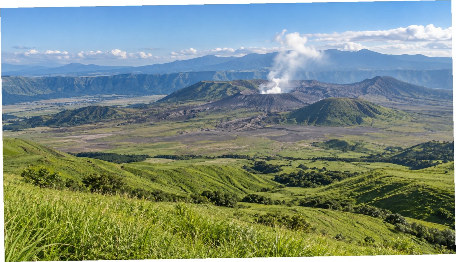 Pascoli verdi della caldera di Aso con il cratere vulcanico sullo sfondo